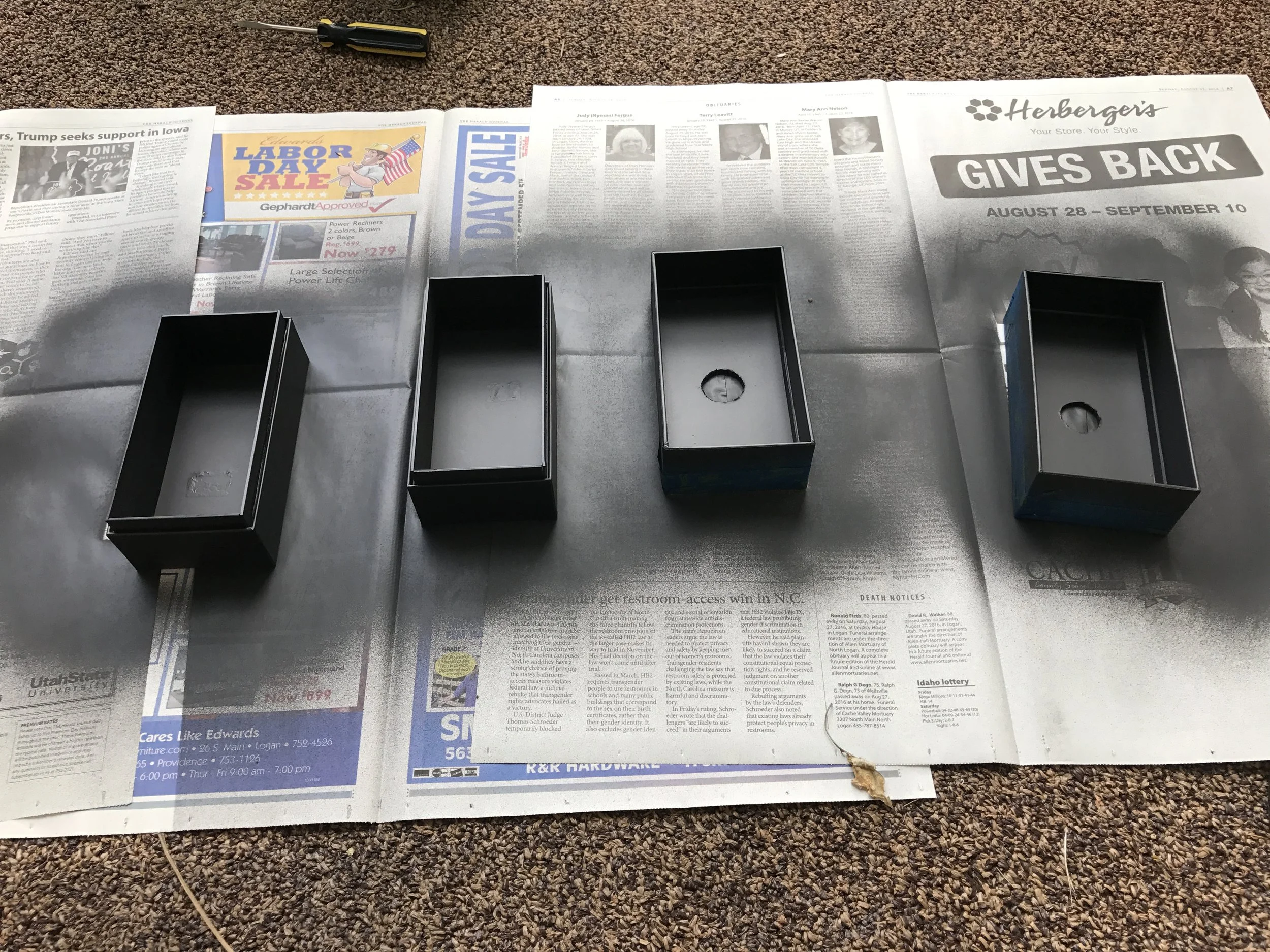  Interior of boxes being painted with matte black paint 